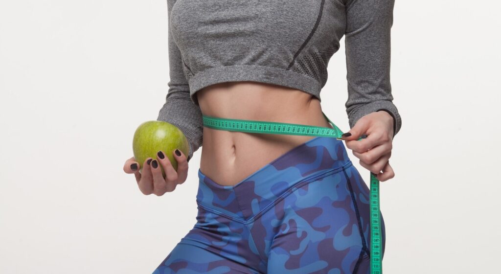 beautiful slim woman holding green apple with several color measuring tapes her waist 137441 1852