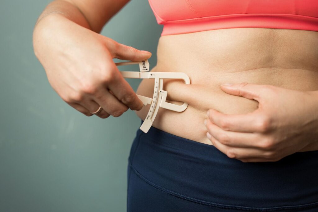 woman measuring her body skin fat with fat caliper 746318 5063