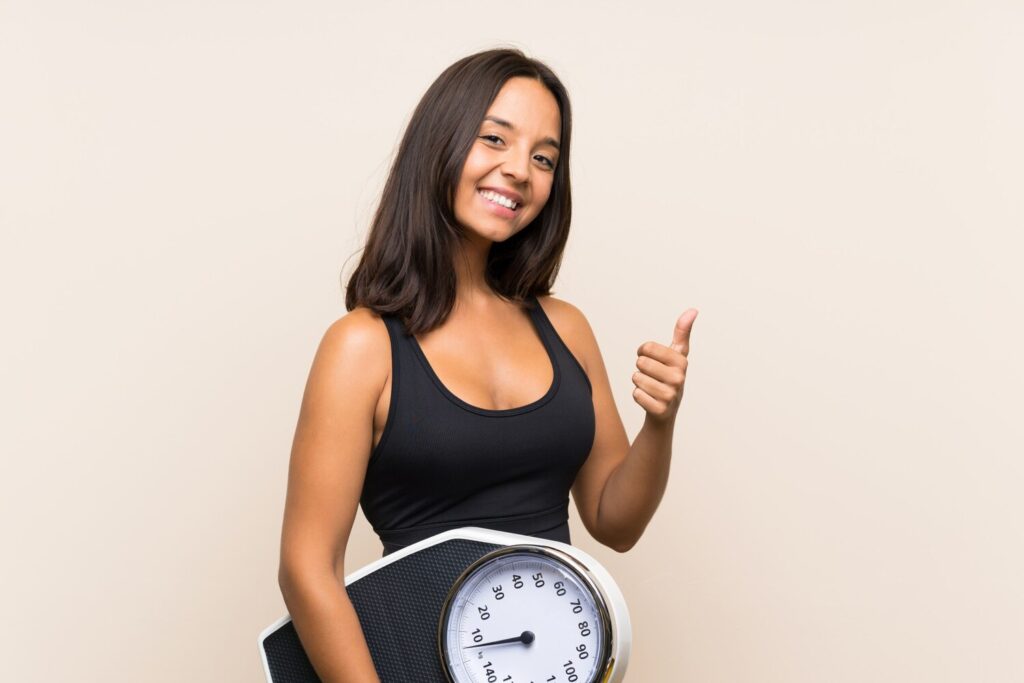 young sport girl with weighing machine isolated wall 1368 54387